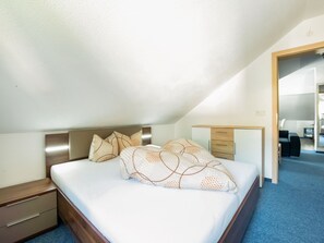 Ein Schlafzimmer mit Bett, Nachttisch, Kommode und Schreibtisch.