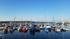 A marina with multiple boats docked, calm water, and a clear blue sky. - Zonnehof in het Geiseltal (Mücheln (Geiseltal))