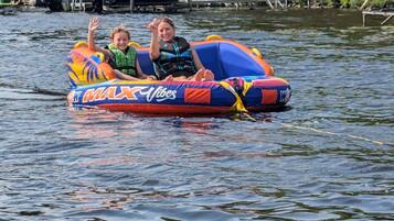 Two people on a colorful inflatable raft floating on water.
