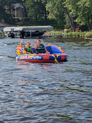 Two people on a colorful inflatable raft floating on water.