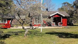 A red building with a sloped roof, a porch, and a flagpole. - 8 Person Holiday Home in Hogklint-by Traum (Visby)