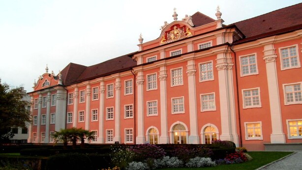 A large, pink building with classical architecture, featuring multiple windows and a symmetrical facade. - Lake Constance Hearts (Meersburg)