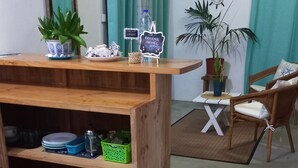 Un escritorio de madera con estantes, una planta pequeña y un letrero de bienvenida.