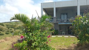 Un edificio moderno con un balcón que da a un jardín exuberante.