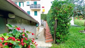 A residential building with a narrow front garden, a wooden staircase, and a variety of plants. - Holiday Home in Lucca With Pool & Garden (Pescaglia)