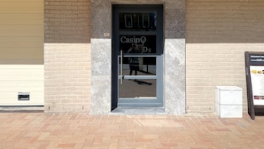 A casino entrance with a digital display, a door, and a trash bin. - Apartment in Nieuwpoort Near the Beach (Nieuwpoort)