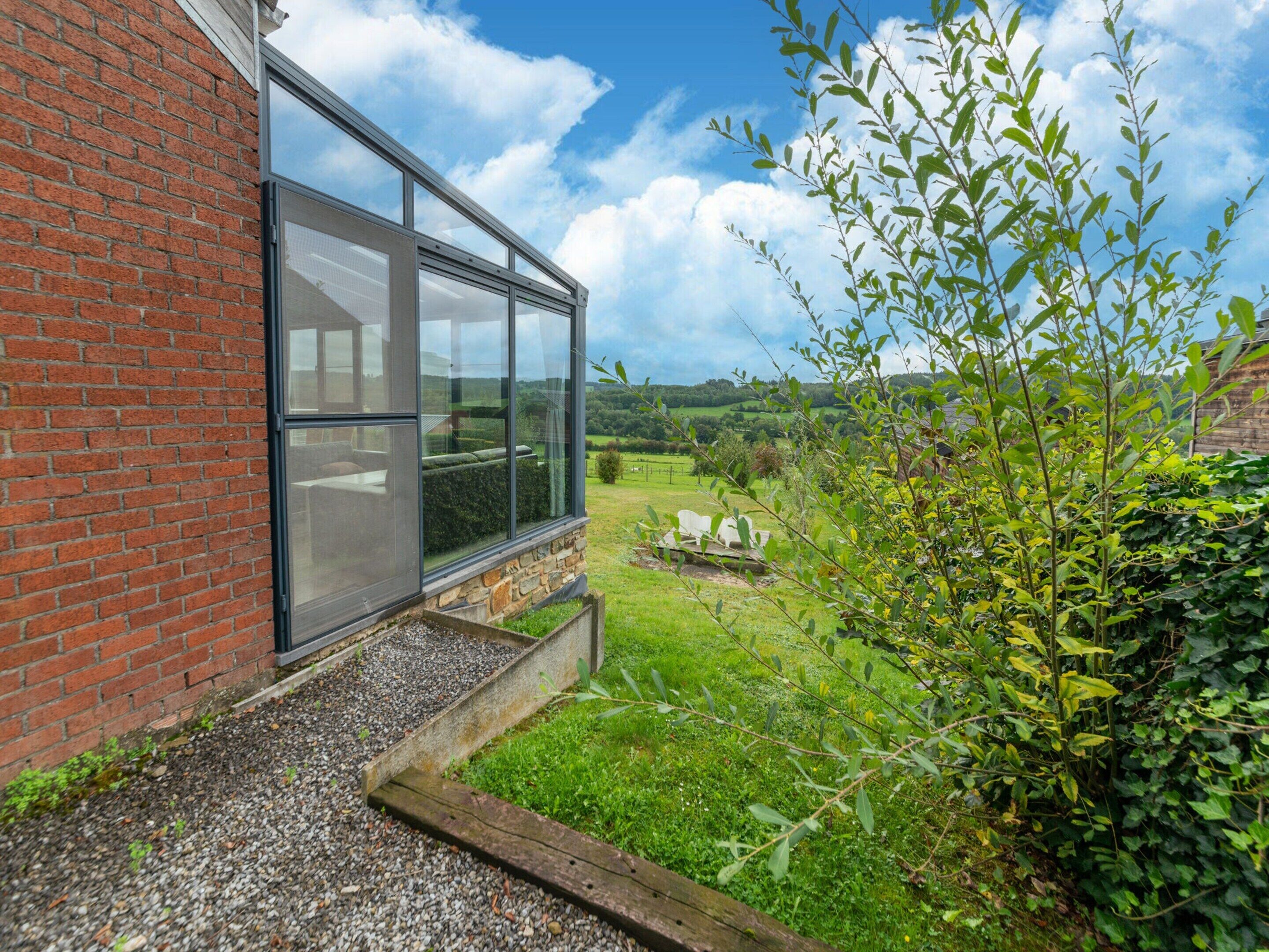 A modern building with a large glass window and a brick wall.