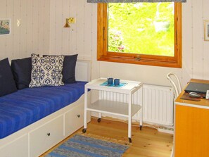 A compact room with a bed, a small desk, a radiator, and a window with a view of greenery. - 4 Star Holiday Home in Malmkoping (Malmkoping)