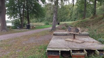 A park with picnic tables, a dirt path, and a wooden platform with benches.
