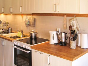 A kitchen with a stove, sink, and various kitchen utensils. - 4 Star Holiday Home in Malmkoping (Malmkoping)