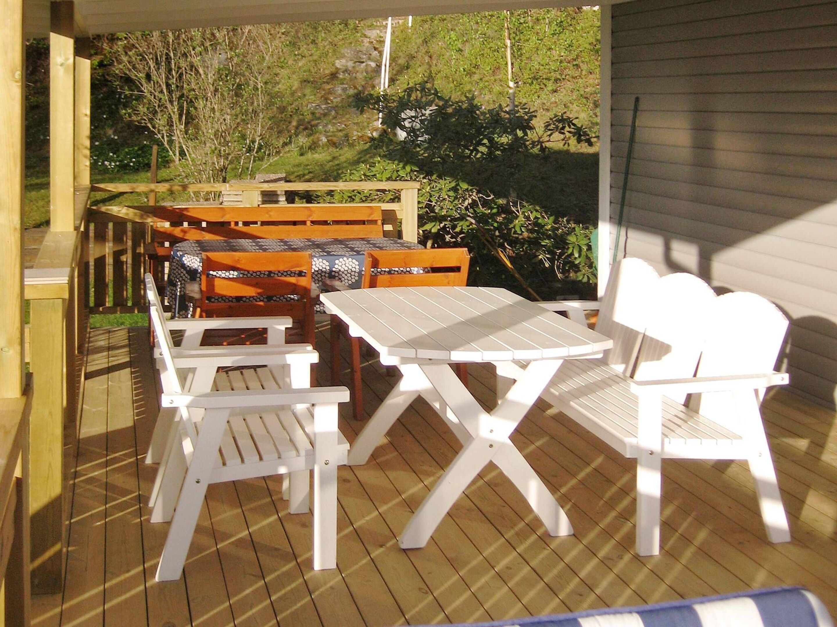 Eine Terrasse im Freien mit Holzmöbeln und einem Tisch.