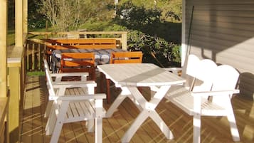 Eine Terrasse im Freien mit Holzmöbeln und einem Tisch.