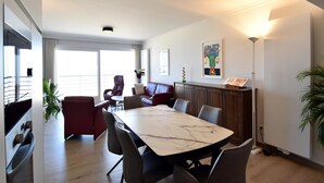 Een moderne eetruimte met een marmeren tafel, lederen stoelen en uitzicht op het buitengebied.