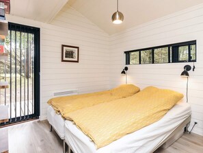 A bedroom with a bed, a window, and a picture on the wall. - 7 Person Holiday Home in Albaek (Aalbaek)