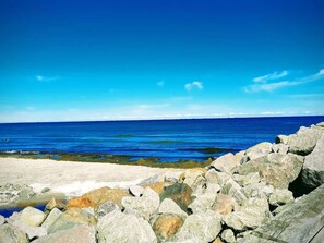 A rocky shoreline with a clear blue sky and calm sea. - 7 Person Holiday Home in Albaek (Aalbaek)