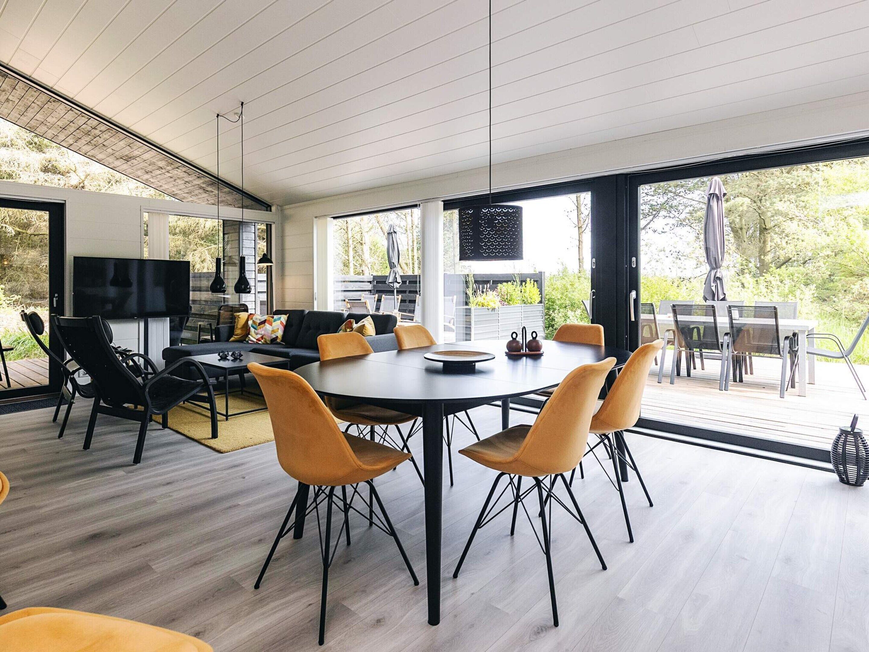 Un intérieur moderne comprenant un coin repas, un canapé et un téléviseur.