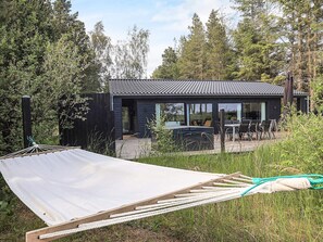 A modern house with a patio area, large windows, and a hammock. - 7 Person Holiday Home in Albaek (Aalbaek)