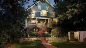 A two-story house with a front porch, a stone staircase, and a well-maintained garden. - The Avenue! Historic Mansion in DT Manitou Springs (Manitou Springs)