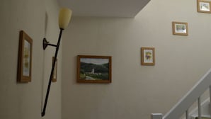 Un escalier avec une rampe et un mur orné de tableaux encadrés.