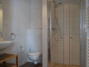 A bathroom with a toilet, sink, and shower. - Holiday Apartment Windrose (Boergerende-Rethwisch)