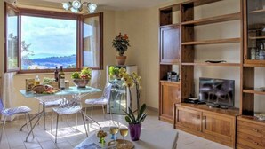 A dining area with a table, chairs, and a view through a window. - Villa Morotti Comfortable Holiday Residence (Montone)