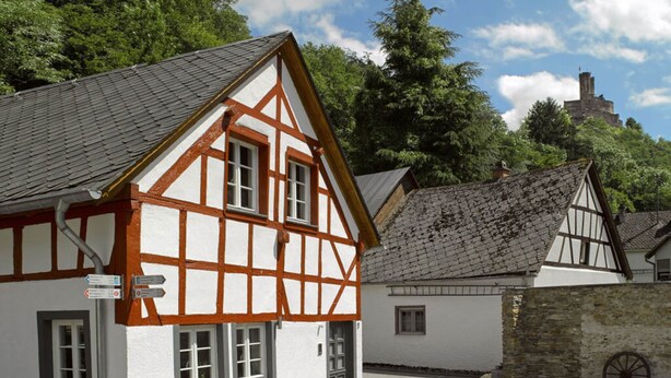 A traditional half-timbered building with a paved courtyard and outdoor seating. - In the Rhein-mosel Holiday Home (Brodenbach)