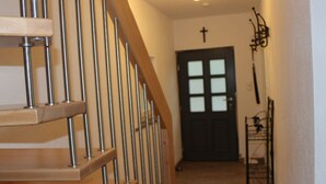 A wooden staircase with metal railings leading to a dark door with a cross above it. - In the Rhein-mosel Holiday Home (Brodenbach)
