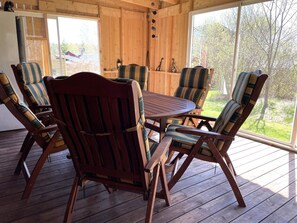 A wooden deck with a round table and six striped chairs. - 5 Person Holiday Home in Ulrika-by Traum (Ulrika)