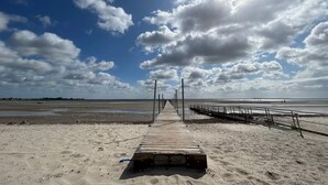 A wooden pier leading to a beach with a clear sky and clouds. - 8 Person Holiday Home in Bjert (Bjert)