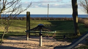 Leikkikentällä on liukumäki, hiekkalaatikko ja piknikpöytä.