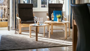 Une pièce comprenant deux fauteuils, une petite table et une plante en pot.