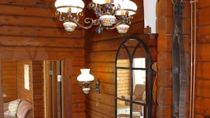 Ein Holzhütten-Interieur mit einem Bett, einem Spiegel und einem Kamin.