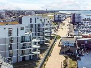 Ein Küstenwohngebiet mit modernen Gebäuden, einer Marina und freiem Blick auf das Meer.