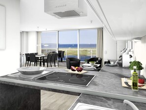 A modern kitchen with a large island, dining area, and a view of the ocean. - Holiday Home in Wendtorf (Wendtorf)