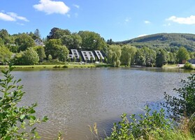 Un lago con un edificio al fondo.