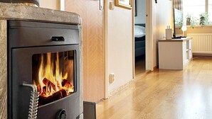 Une cuisine moderne dotée d’un poêle à bois, d’un plancher en bois et donnant sur une chambre.