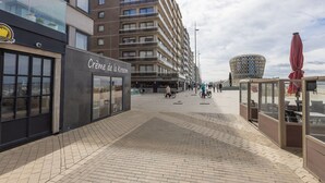 Un trottoir dallé menant à une boutique dont l’enseigne indique « Crème de la Kreme ».