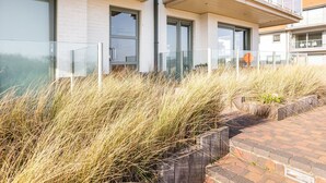 Un edificio moderno de dos plantas con ventanas amplias y un balcón.