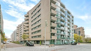 A modern multi-story apartment building with a flat facade, large windows, and a paved ground floor. - Stylish Stay by the Seafront (Middelkerke)