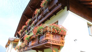A traditional wooden balcony with flower boxes and a white building facade. - Apartment in Tropolach With Sauna (Hermagor-Pressegger See)