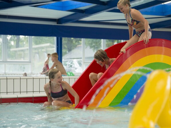 A water slide with a rainbow design in a swimming pool.