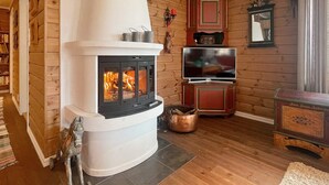 A cozy living room with a wood-burning stove, a television, and a cabinet. - 8 Person Holiday Home in Valldal (Fjord)