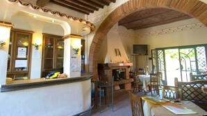 Un interior acogedor con chimenea de piedra, muebles de madera y piso de baldosas.
