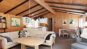A cozy, rustic interior with a wooden ceiling, a dining area, a kitchen, and a living room furnished with a sofa, a table, and chairs. - 5 Person Holiday Home in Frederiksvaerk (Frederiksvaerk)