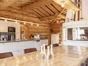 A kitchen with wooden beams, a central island, and a large window.
