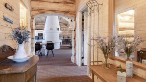 A wooden interior with a brick floor, a white kitchen area, and a dining table with chairs. - 24 Person Holiday Home in Laeso-by Traum (Læsø)