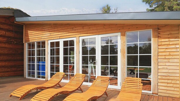 A wooden deck with sun loungers and a glass door leading to an outdoor area. - 24 Person Holiday Home in Laeso-by Traum (Læsø)