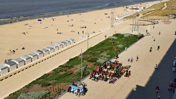 A beach with a paved walkway, benches, and a variety of people and vehicles. - Sleek Stay by the Sea (Middelkerke)