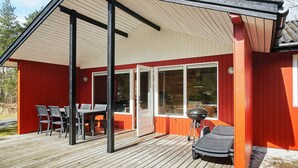A wooden deck with a covered patio area, a barbecue grill, and a dining table with chairs. - 6 Person Holiday Home in Aakirkeby (Akirkeby)