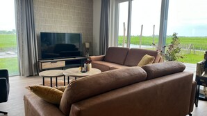Una sala de estar moderna con un sofá de cuero, un televisor de pantalla plana y una mesa de centro.
